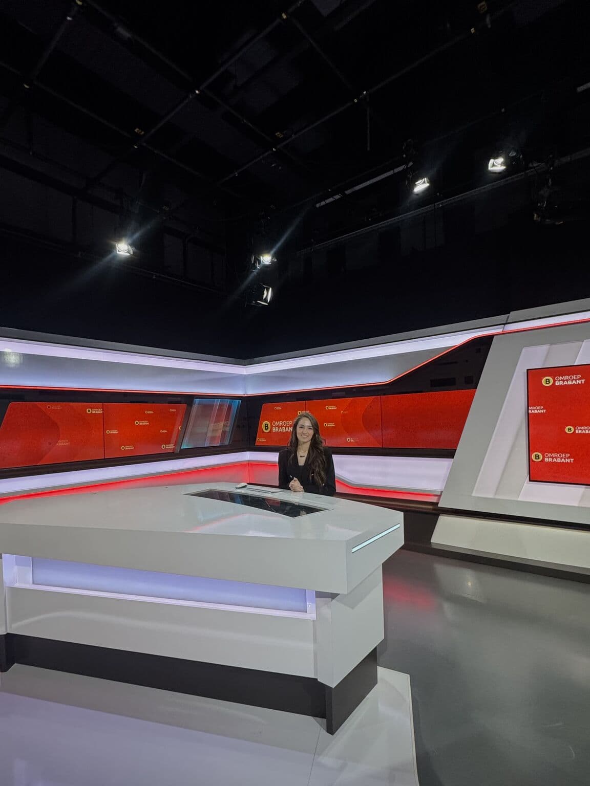 Julia Awad aan het bureau tijdens een uitzending bij Omroep Brabant